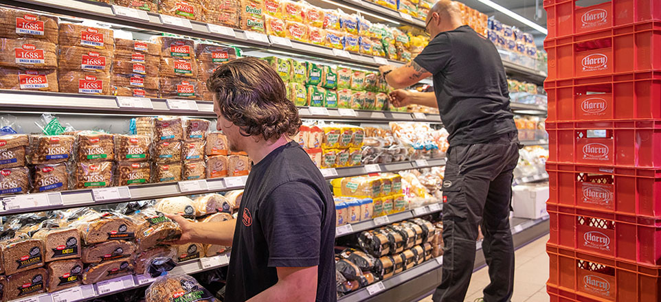 Mitarbeitende von Harry Brot beim Einräumen der Regale im Markt