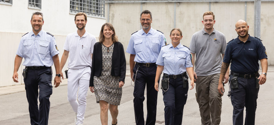 Sieben Personen in unterschiedlicher Dienstkleidung.