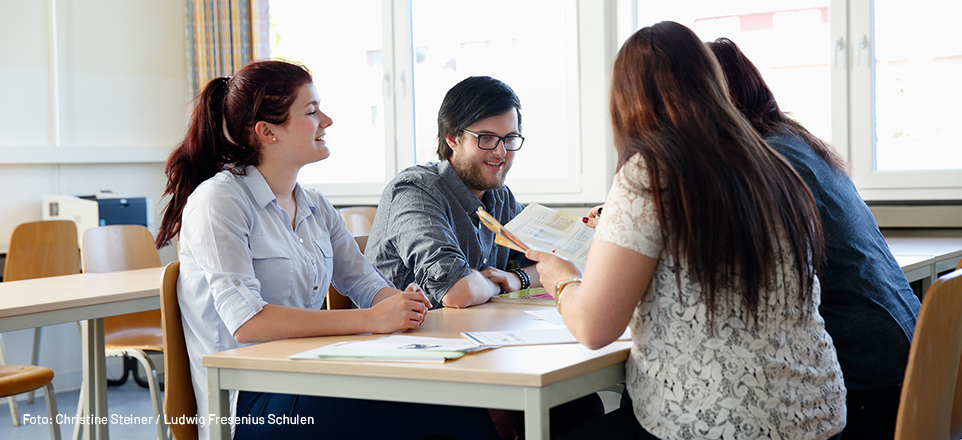 Schüler/innen unterhalten sich am Tisch 