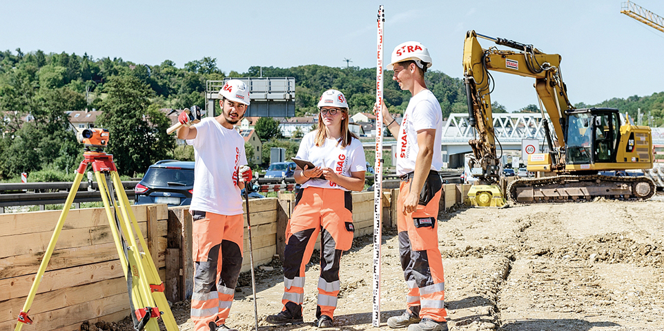 Drei Bauarbeiter/innen vermessen auf Baustelle